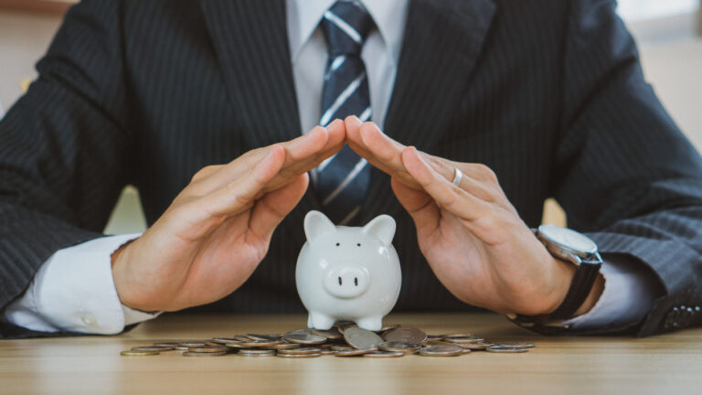 man protecting the piggybank in hand,