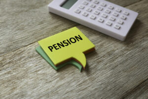 Sticky notes next to calculator with the word "Pension"